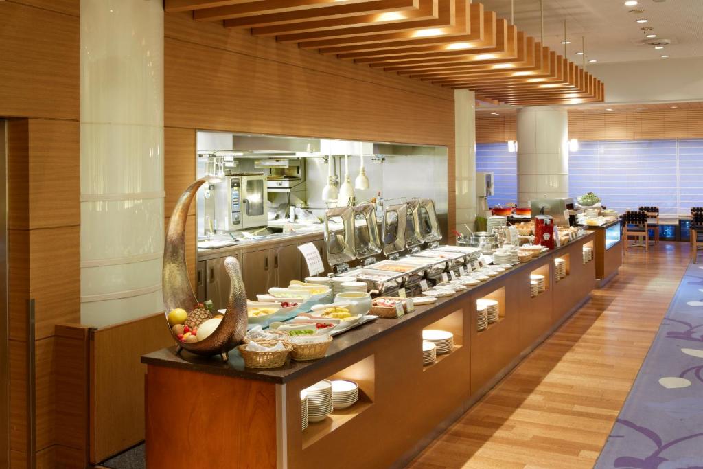 a large kitchen with a long buffet of food at Grand Prince Hotel Takanawa in Tokyo