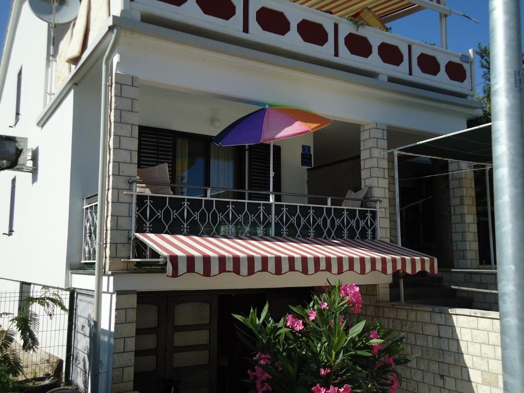 a colorful umbrella on the balcony of a house at Studio Apartment Carli in Savudrija