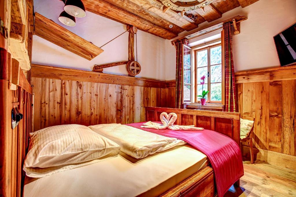 una camera con un letto in una stanza con pareti in legno di Welterbe-Wirtshaus Steegwirt a Bad Goisern