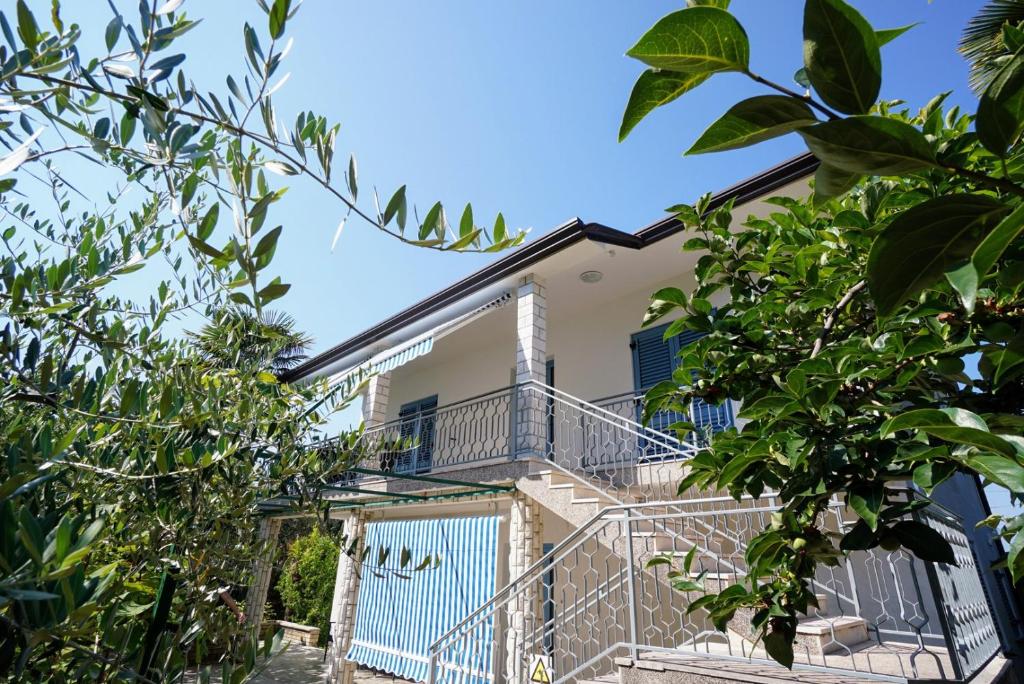 a house with a balcony and trees at Apartment Nino Savudrija in Bašanija