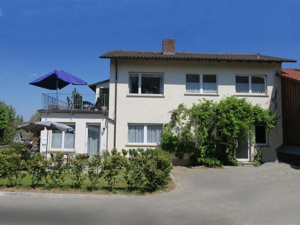 康斯坦茨的住宿－Haus Hornwiesenstraße，白色的房子,阳台配有遮阳伞