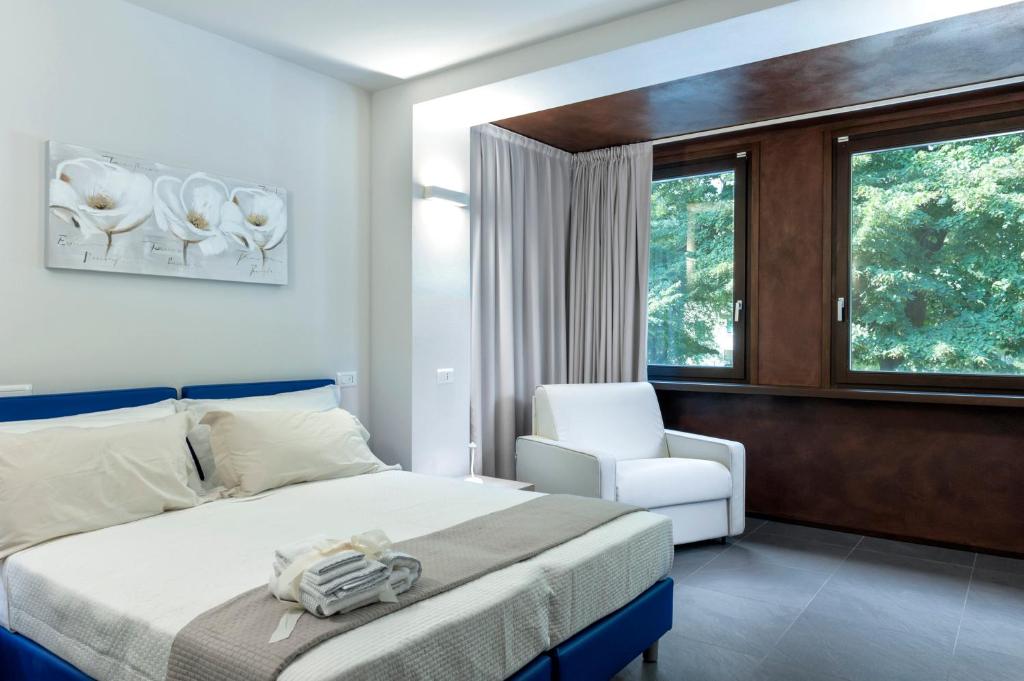 een slaapkamer met een bed, een stoel en een raam bij StraVagante Hostel & Rooms in Verona