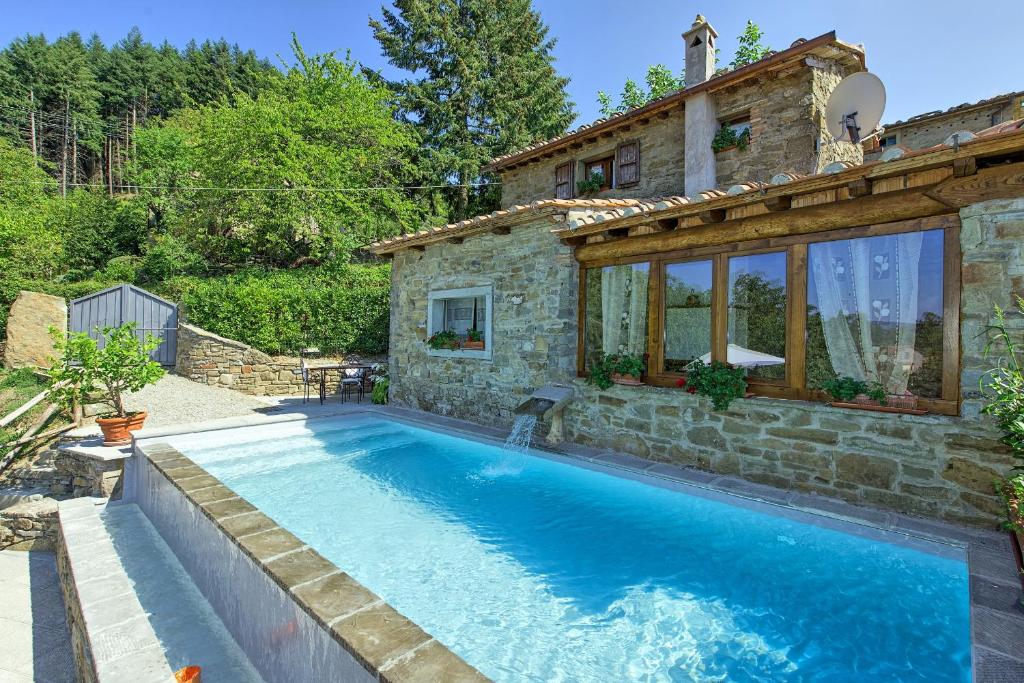 a house with a swimming pool in front of a house at Casa Margherita 3 by PosarelliVillas in Piegaio