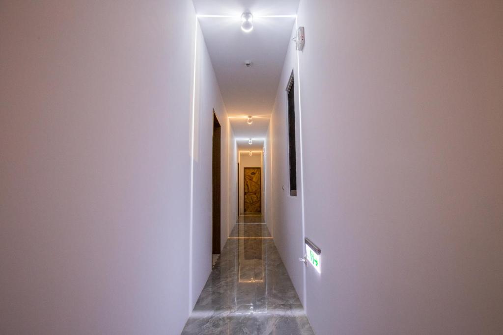 a hallway with a white wall and a door at 漫步山嵐 A walk in the mist in Lugu Lake