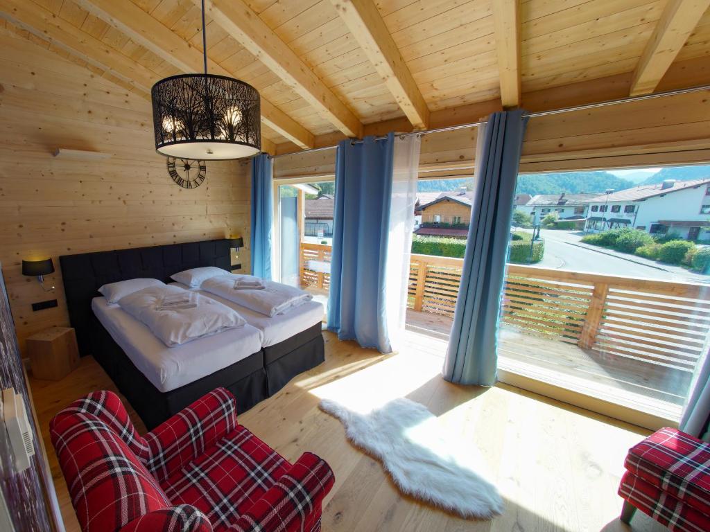 a bedroom with a bed and a large window at ALPENLIEBE Design Hotel in Inzell
