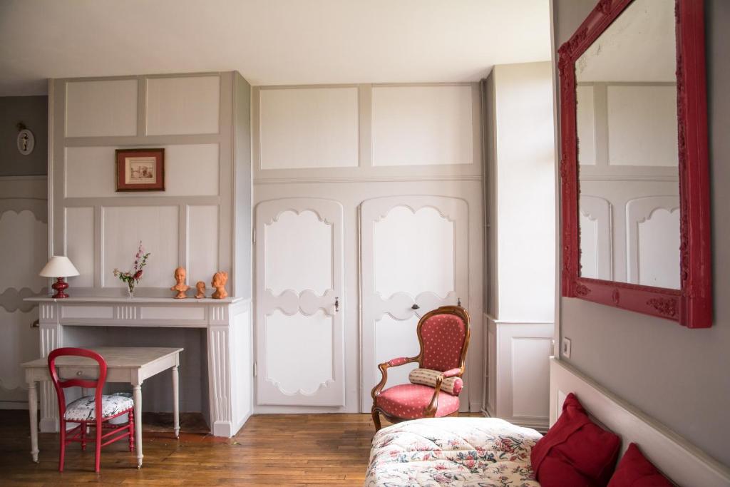 a room with a bed and a table and chairs at Chambres d'hôtes de charme Le Pradel in Monceaux-sur-Dordogne