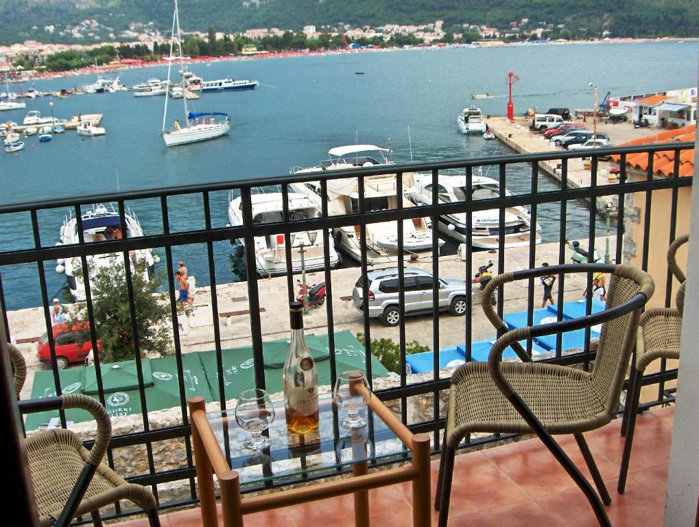 een balkon met een tafel en stoelen en uitzicht op een haven bij Apartments Aleksić Old Town in Budva