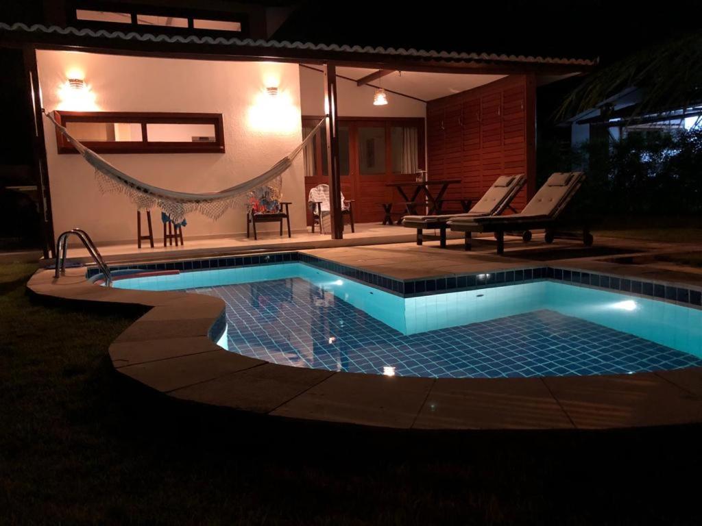 una piscina con una hamaca junto a una casa en #VEMPRAPIPA - Casa no Madeiro em Condomínio - Piscina & WIFI, en Pipa