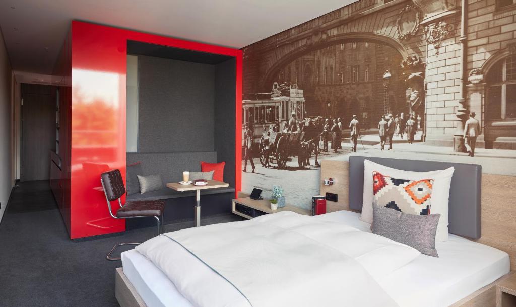a bedroom with a large white bed and a red wall at Living Hotel Frankfurt in Frankfurt