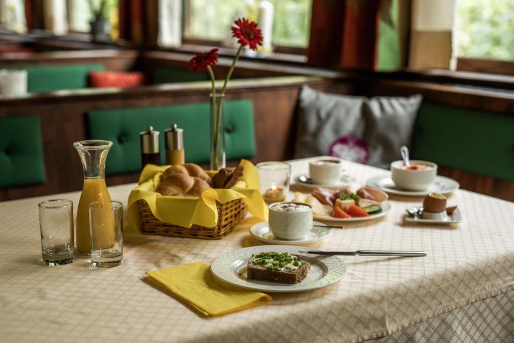 einen Tisch mit einem Teller Essen und einem Korb Brot in der Unterkunft Hotel Obermayr in Ebenau