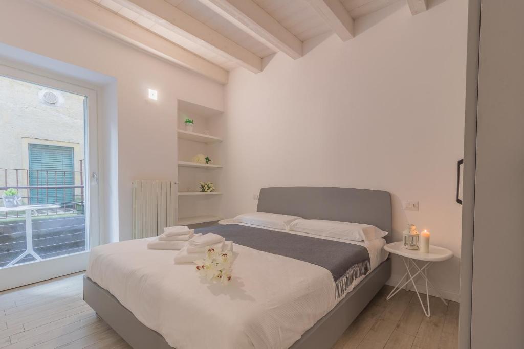 biała sypialnia z dużym łóżkiem i oknem w obiekcie Little Nest Flat w mieście Varenna