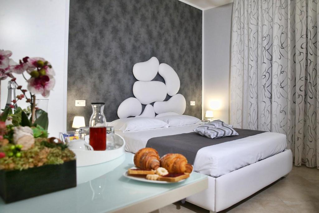 una habitación con una cama y una mesa con un plato de pan en B&B Pompei Olympus, en Pompeya