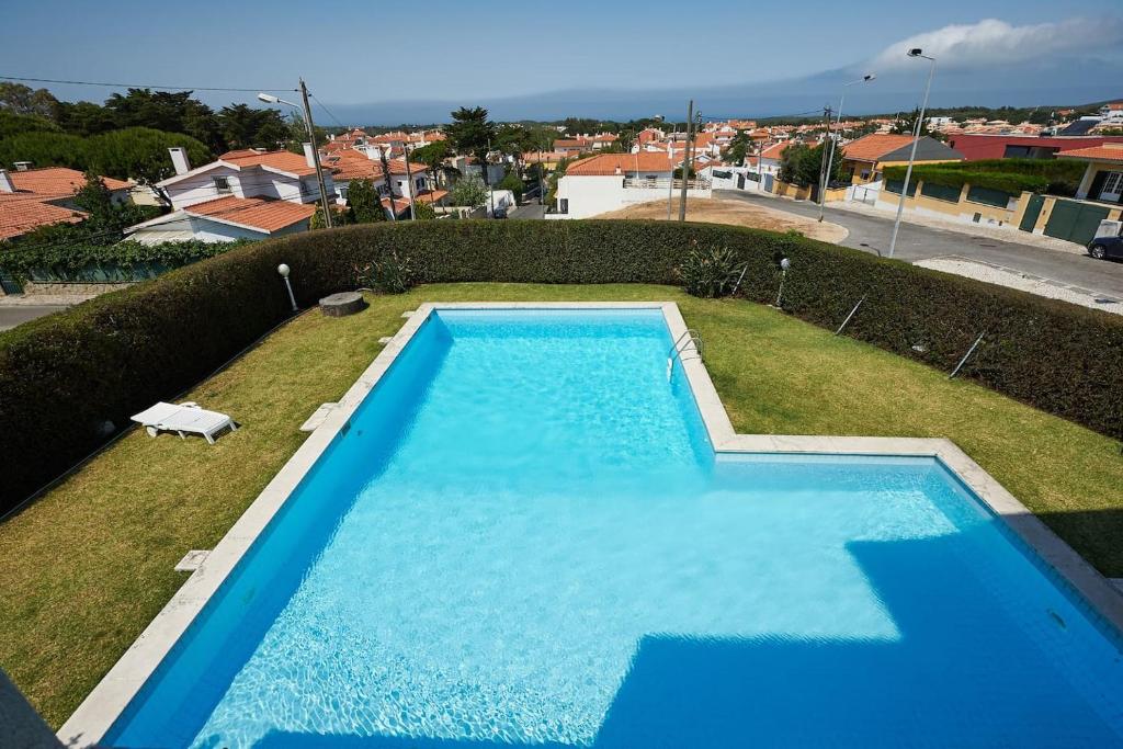 une grande piscine bleue dans une cour dans l'établissement Relaxing Villa w/pool up to 6 people Cascais, à Cascais