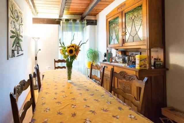 una mesa de comedor con un jarrón de flores. en Chambres d'hôtes chez Pierrot et Flo en Vugelles-La Mothe