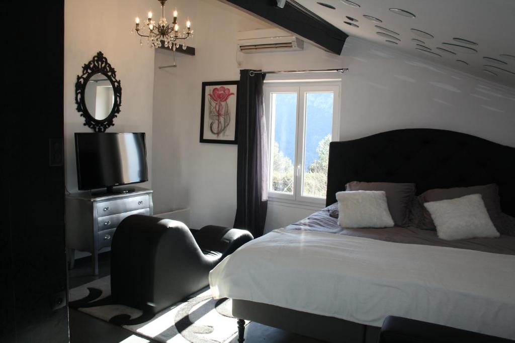 sypialnia z łóżkiem, telewizorem i oknem w obiekcie LA PARENTHESE AMOUREUSE w mieście Tulon