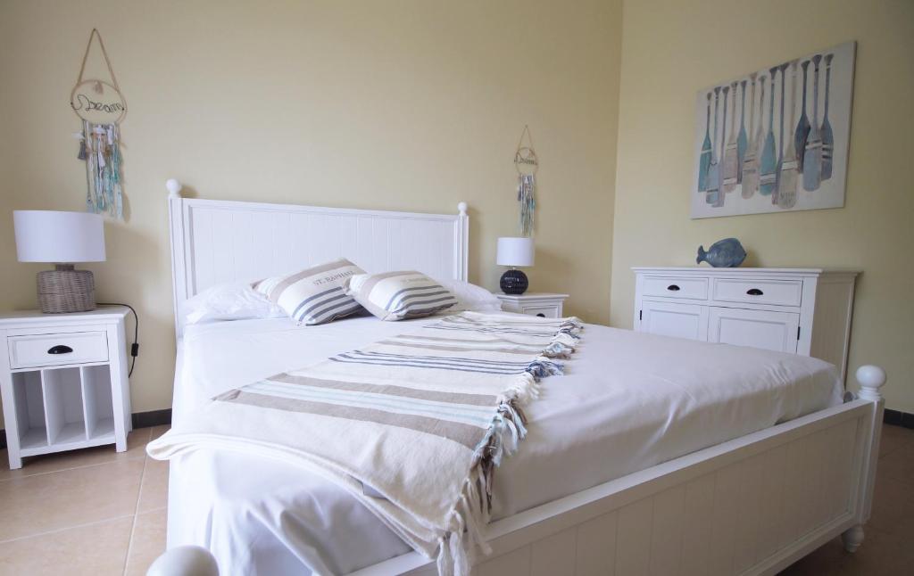 a bedroom with a white bed with two night stands at Villa dei Ginepri in Gallipoli