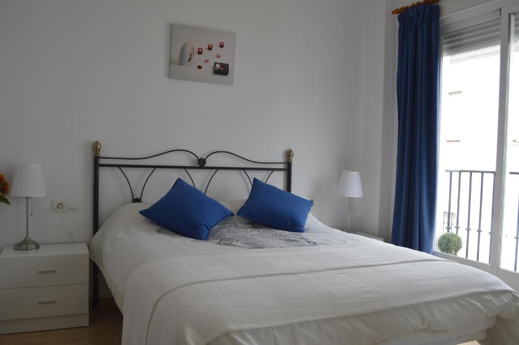 a bedroom with a large bed with blue pillows at Apartamento Steven in Ardales