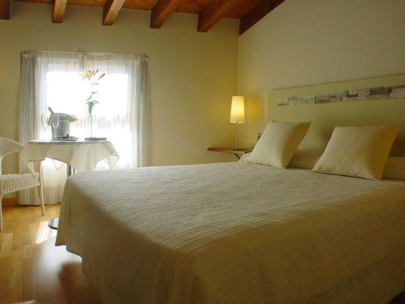 a bedroom with a bed and a table and a window at El Mirador de las Monjas in Trujillo