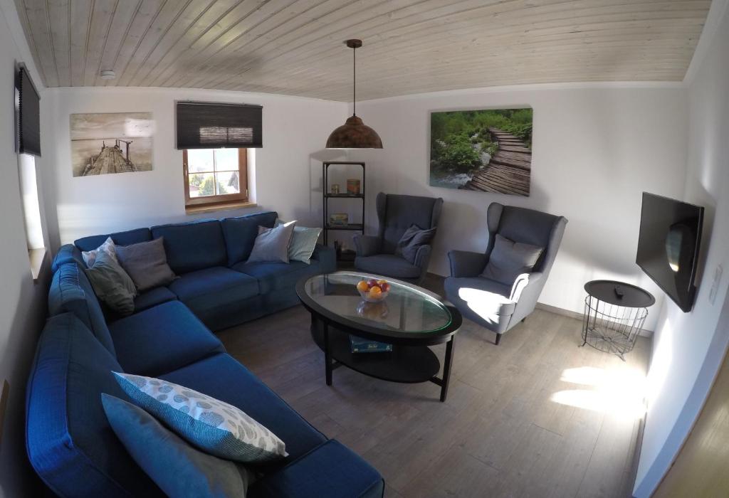 a living room with a blue couch and a table at Haus Pistenblick in Russbach am Pass Gschütt