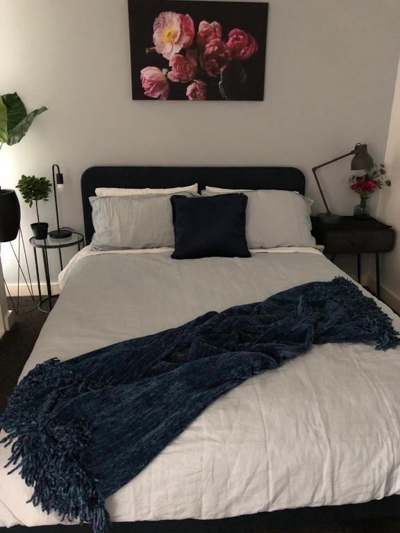 a bed with a blue blanket on top of it at Fantastic Southbank Apartment in Melbourne