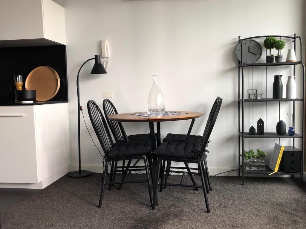 a dining room table with chairs and a vase on it at Fantastic Southbank Apartment in Melbourne