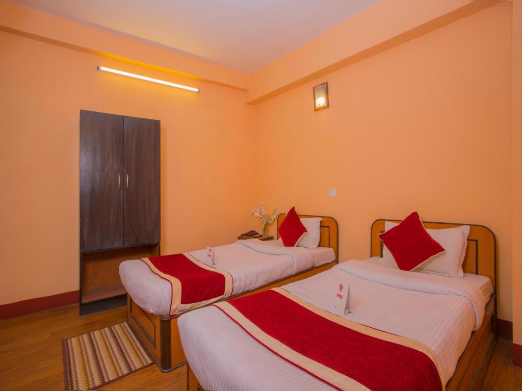 a room with two beds with red and white sheets at Hotel Premium in Kathmandu