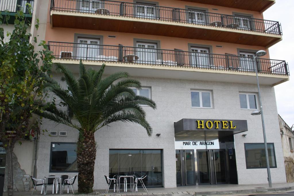 a hotel with a palm tree in front of it at Hotel Mar de Aragón in Caspe