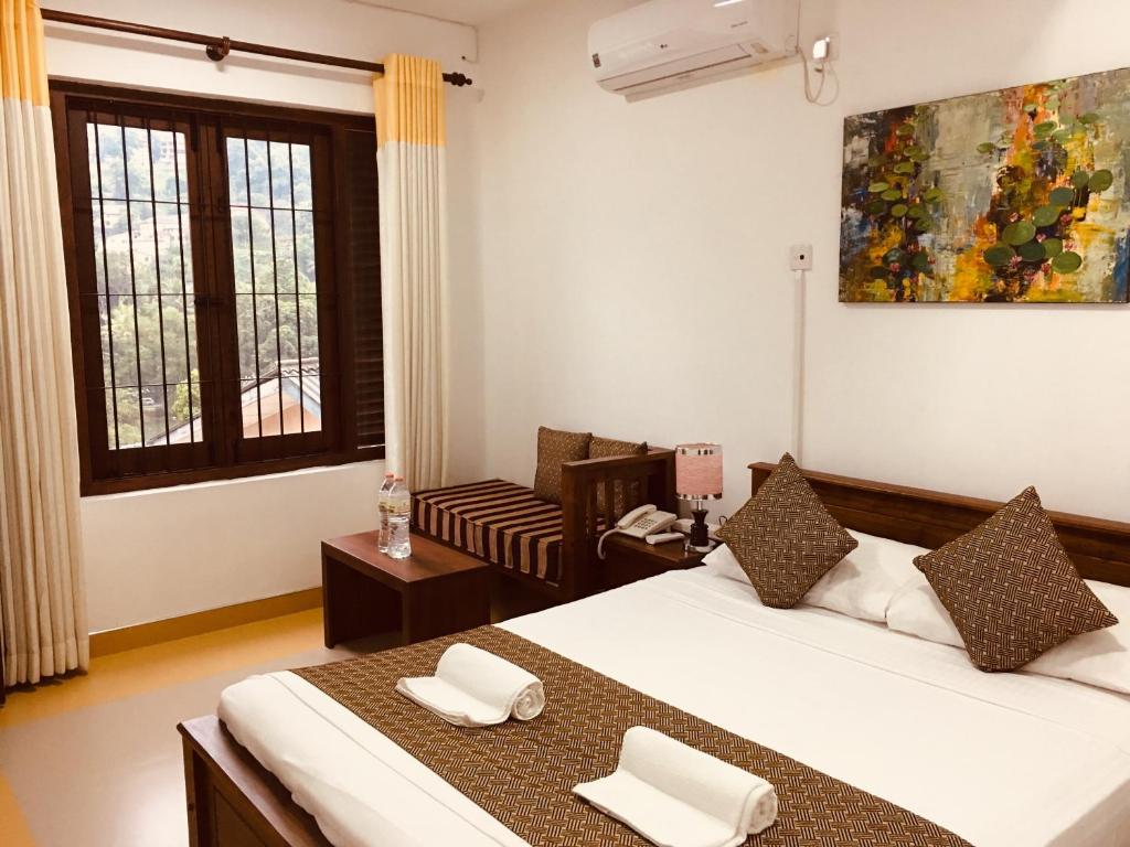 a bedroom with a bed and a chair in it at Sarvodaya Samma Vaasa Residence in Kandy
