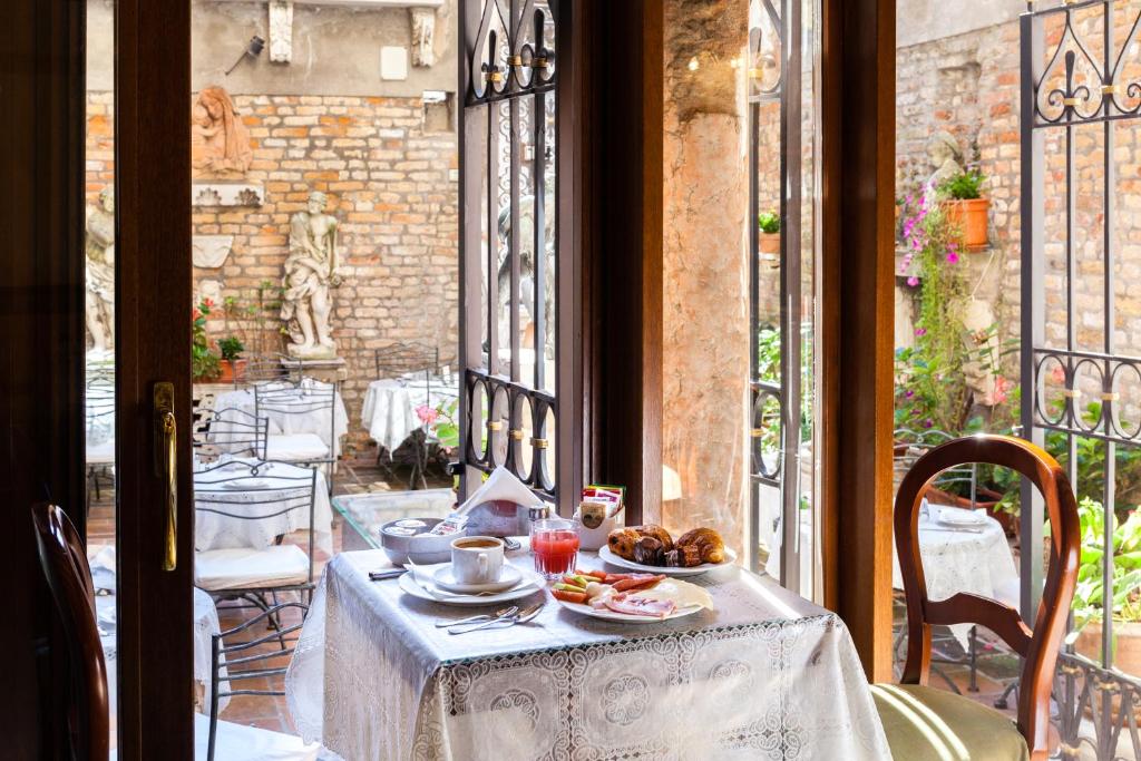 威尼斯的住宿－阿爾蓬特默西尼果酒店，阳台上的餐桌上放着一盘食物