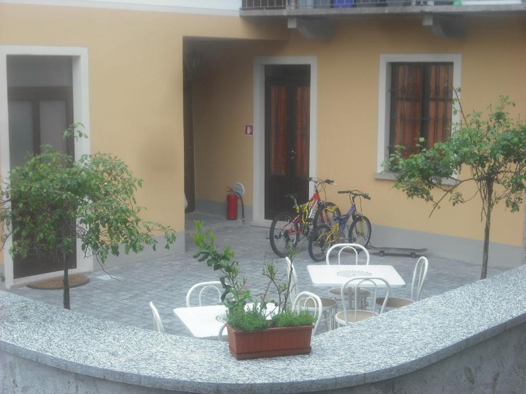 eine Terrasse mit Stühlen, Tischen und Fahrrädern in einem Gebäude in der Unterkunft Casa Giardinetto in Stresa