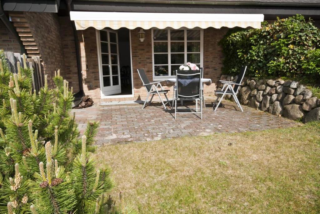 a patio with chairs and a table in front of a house at Freesensün in Munkmarsch