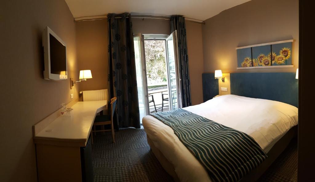Postel nebo postele na pokoji v ubytování Hotel Les Remparts