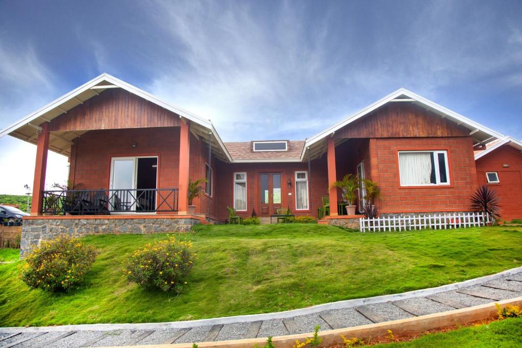 a house with a green lawn in front of it at The Realm in Coonoor