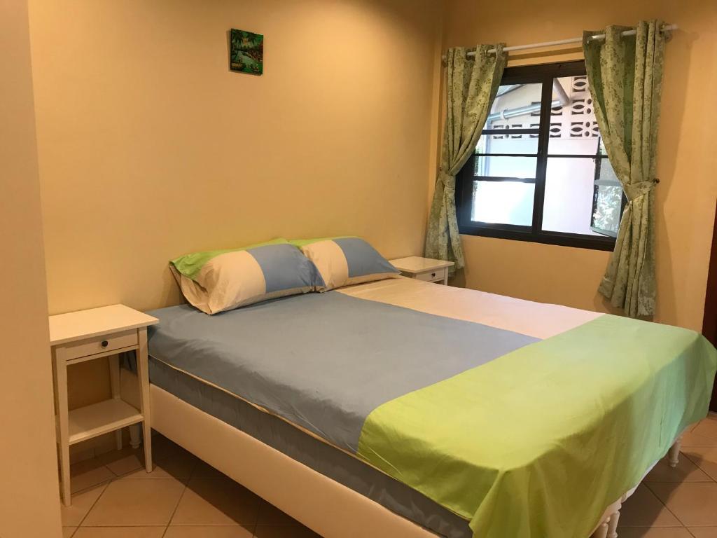 a bedroom with a bed with a desk and a window at Mae Phim, Rayong, Bali Residence Villa in Mae Pim