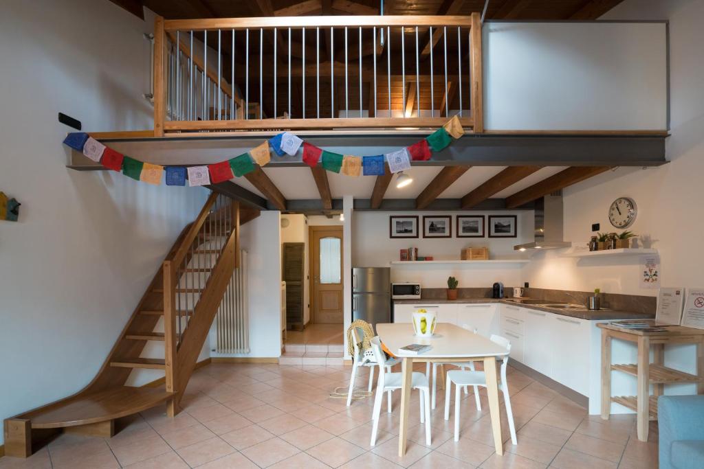 a kitchen with a staircase and a table with chairs at CAMP 4 in Arco