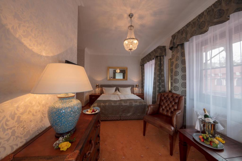 シュトラウスベルクにあるThe Lakeside - Burghotel zu Strausbergのベッドルーム1室(ベッド1台、ランプ付きテーブル付)
