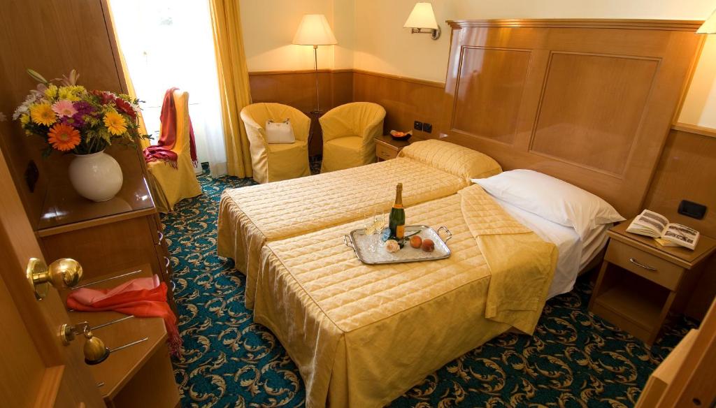 a hotel room with a bed with a bottle of wine on it at Hotel Cinque Giornate in Milan