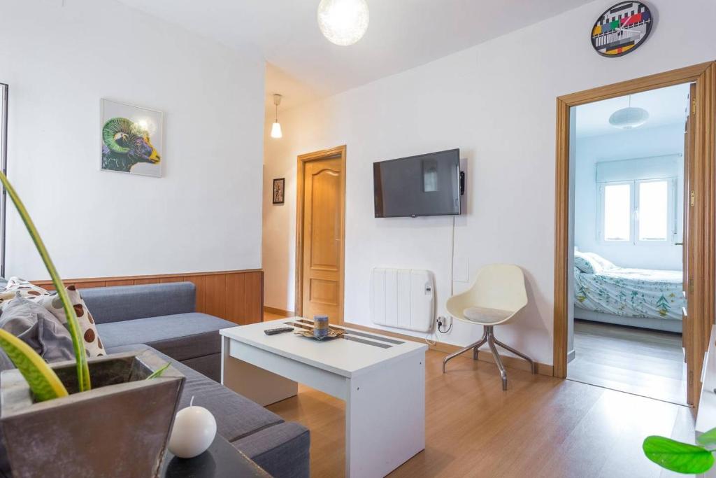 - un salon avec un canapé et une table dans l'établissement Apartamento Urgel, à Madrid