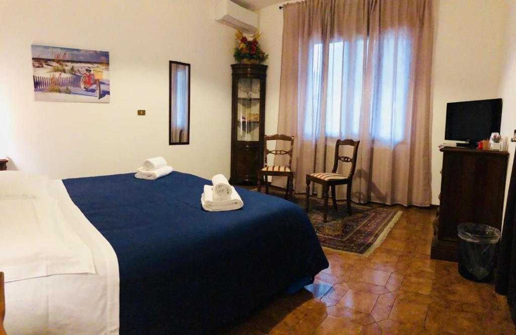 1 dormitorio con 1 cama azul y 2 toallas en CAMINHOUSE, en Padua