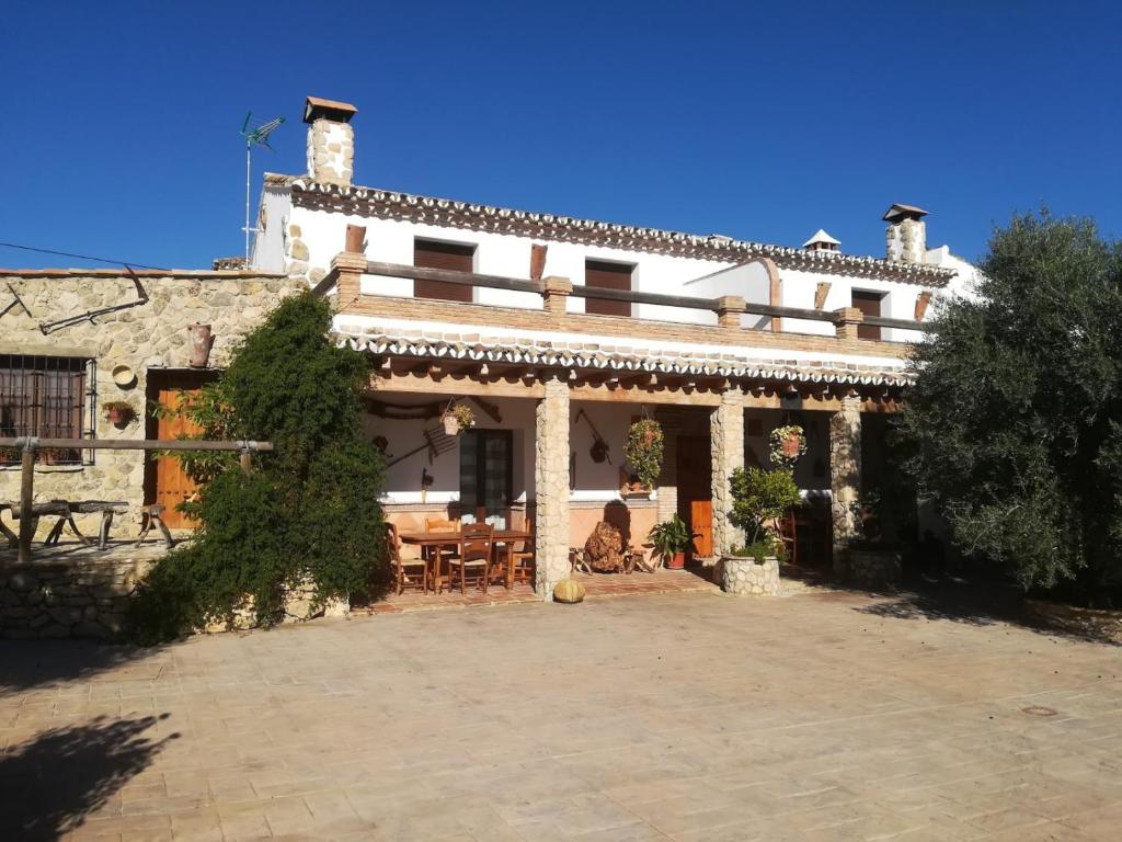 a house with a patio in front of it at Alojamiento Rural La Pila in Ronda