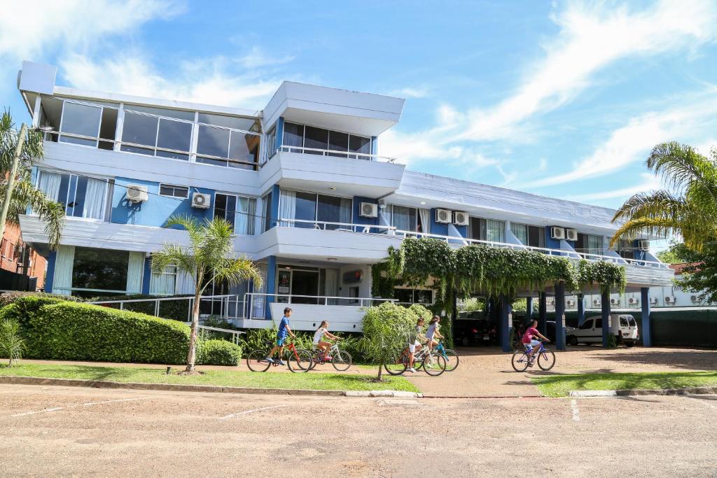 un grupo de niños montando bicicletas frente a un edificio en Apart Hotel Aguasol, en Termas del Daymán