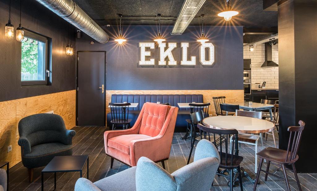 a restaurant with tables and chairs and an exit sign on the wall at Eklo Hotels Lille in Lille