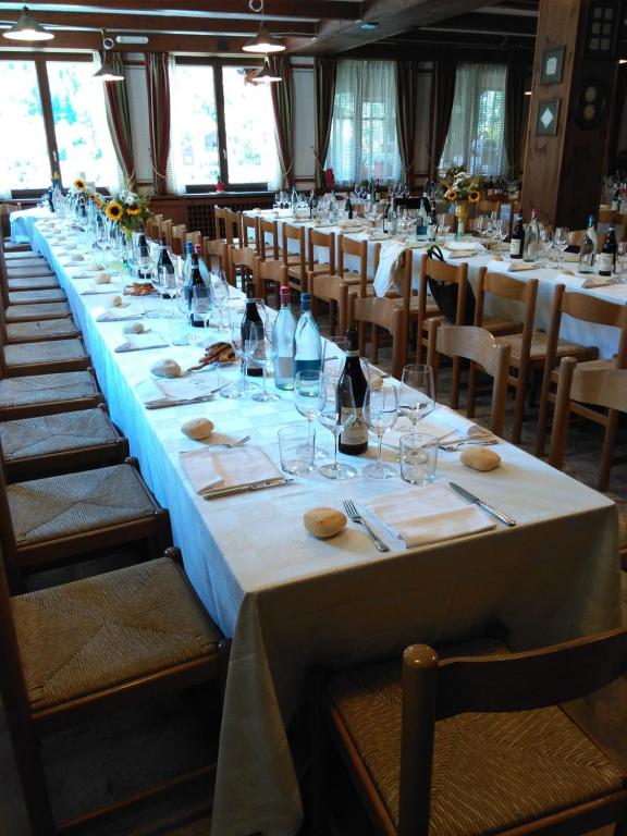 un lungo tavolo in una stanza con tavoli e sedie di Albergo Dei Pescatori a Piode