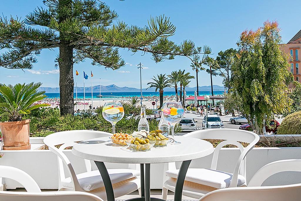 una mesa con un bol de frutas y copas de vino en Apartment CB 2 en Alcúdia