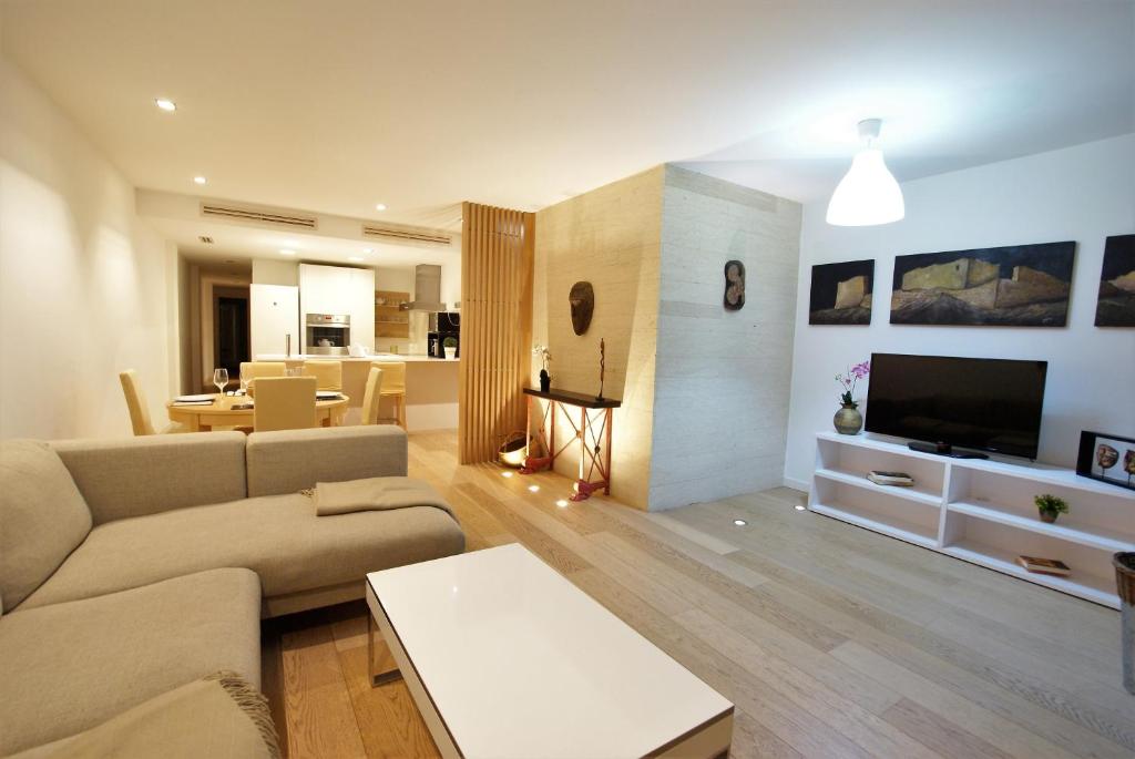 a living room with a couch and a tv and a table at MyFlats San Fernando in Alicante