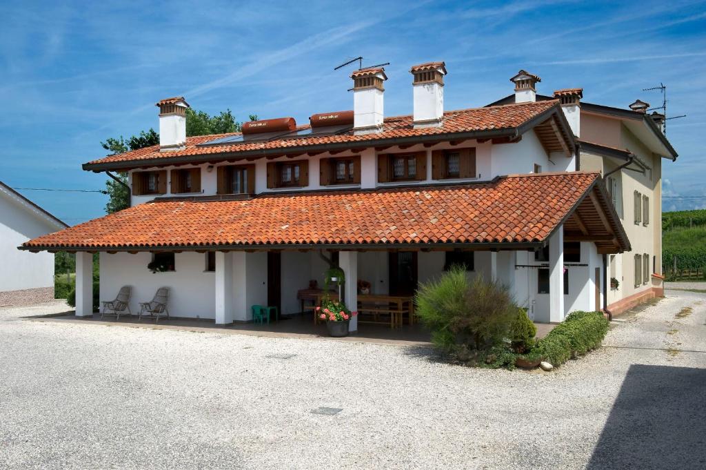 una gran casa blanca con techo rojo en Al Confine, en Cormòns