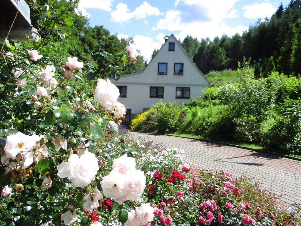 a white house with flowers in front of it at Ferienwohnung "Waldesruh" in Eibenstock
