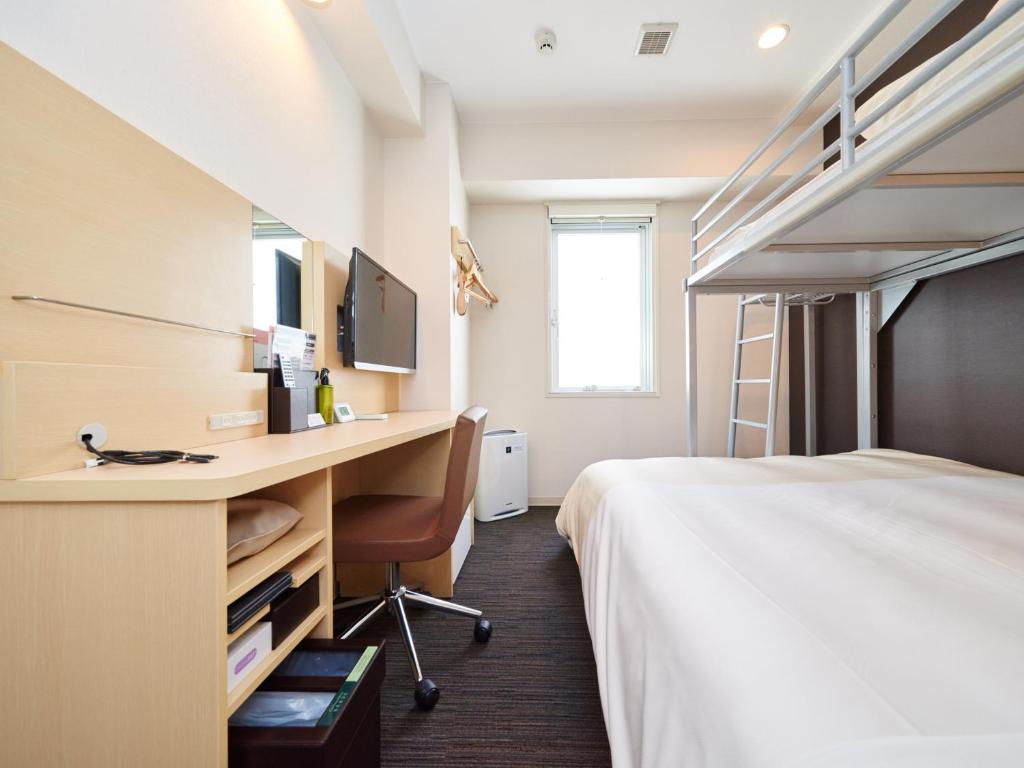 Cette chambre comprend un lit et un bureau avec un ordinateur. dans l'établissement Super Hotel JR Nara Ekimae Sanjo Dori, à Nara