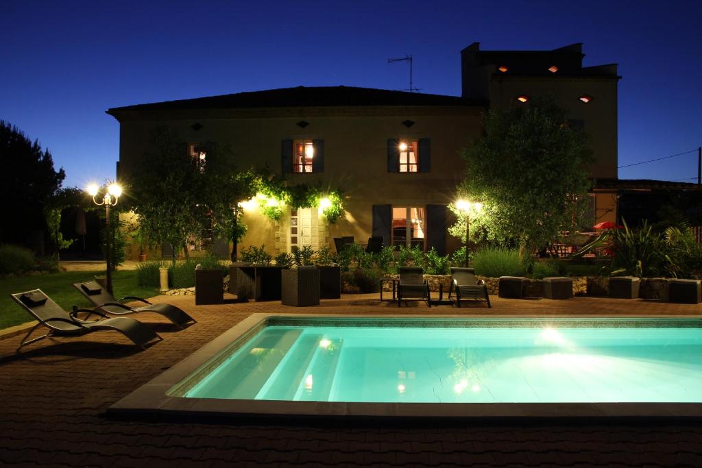 una piscina frente a una casa por la noche en Au Mas du Soleil, en Senouillac