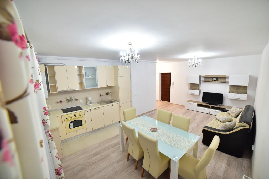 cocina y sala de estar con mesa y sillas en City Residence Sibiu, en Sibiu